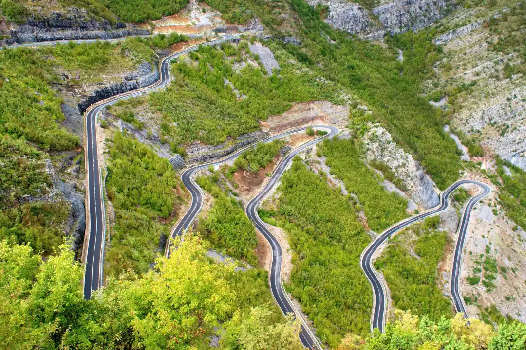 Vue aérienne de virages sur la SH20 en Albanie, lieu idéal pour un road-trip moto